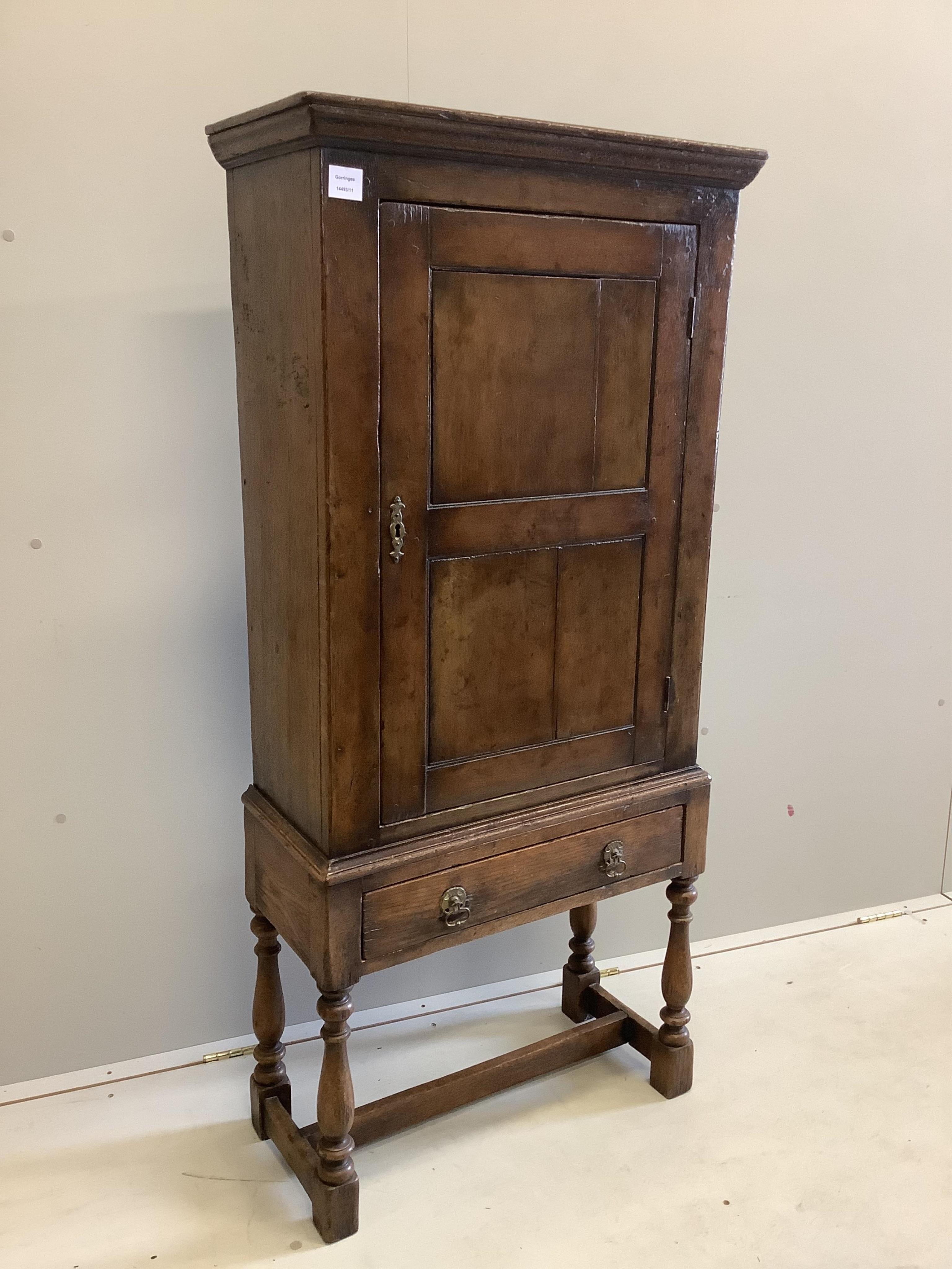 A 17th century style oak cupboard on stand, width 67cm, depth 29cm, height 143cm. Condition - good